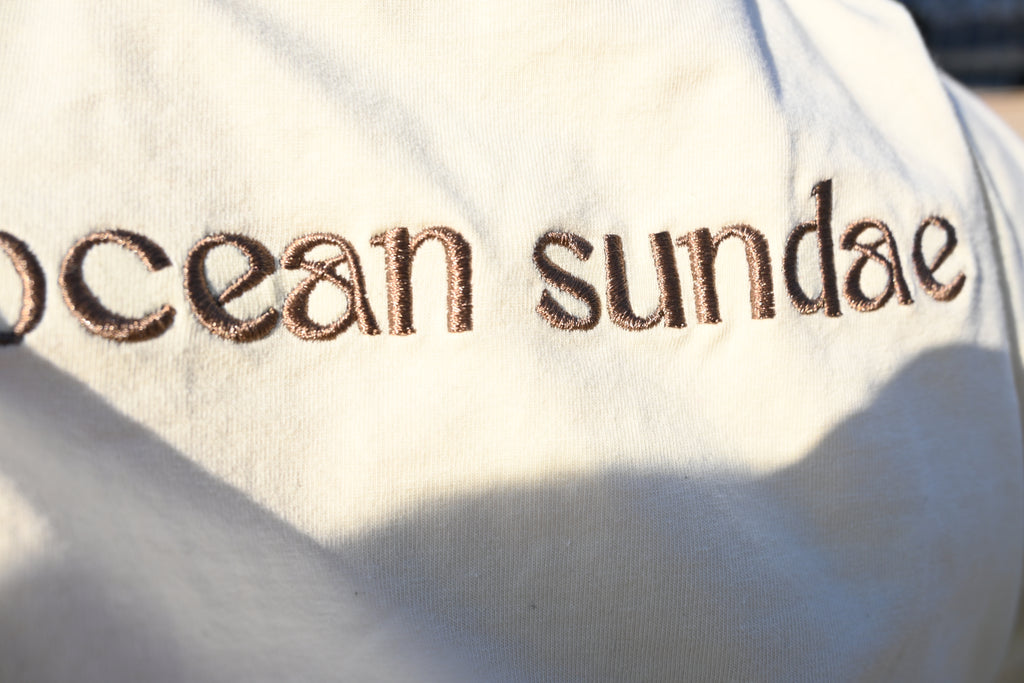 Text 'ocean sundae' embroidered on a white fabric background